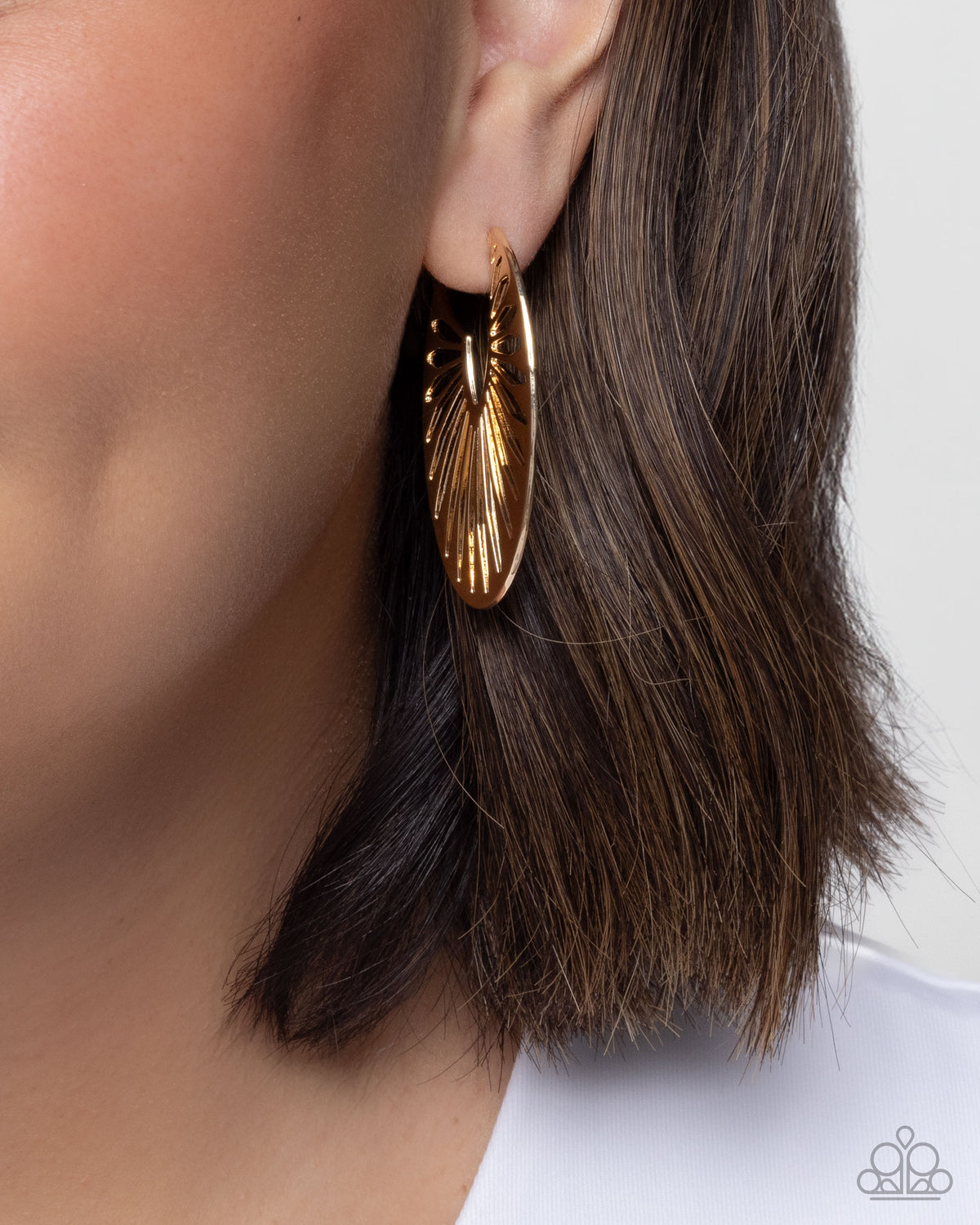 Close-up of Sunset Silhouette gold flared hoop earrings