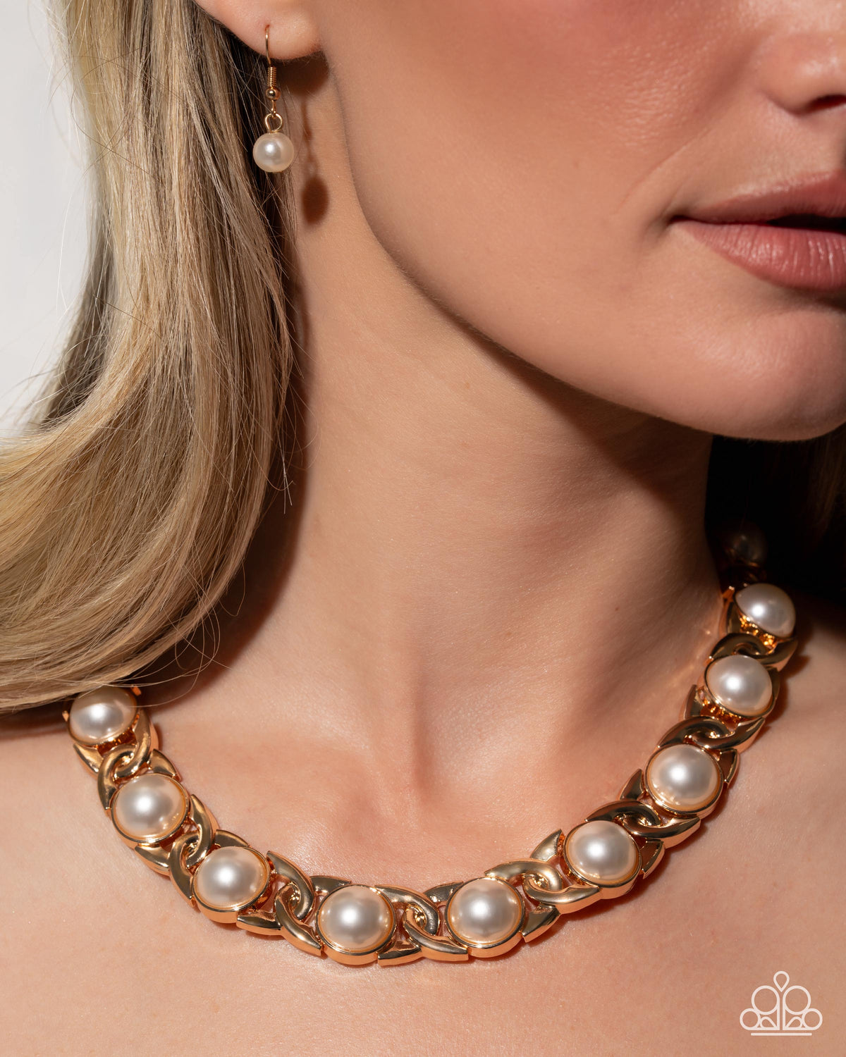 Close-up of Poised Parade gold and white pearl necklace with matching earrings